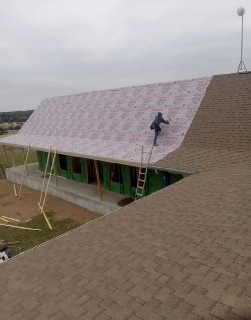 Worker preparing underlayment for a metal roof installation in Tyrone
